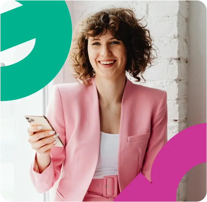 Woman in a pink pant suit holding a mobile phone