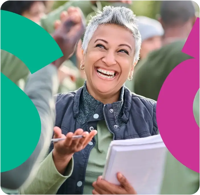 Short haired woman holding a booklet and laughing